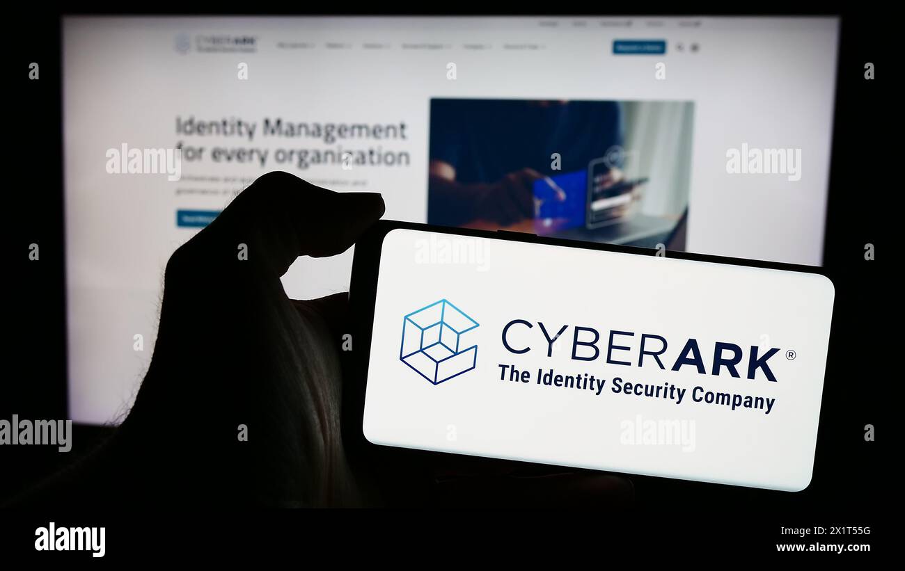 Person mit Smartphone und Logo des US-amerikanischen Identitätssicherheitsunternehmens CyberArk Software Inc. Vor der Website. Schwerpunkt auf dem Display des Telefons. Stockfoto