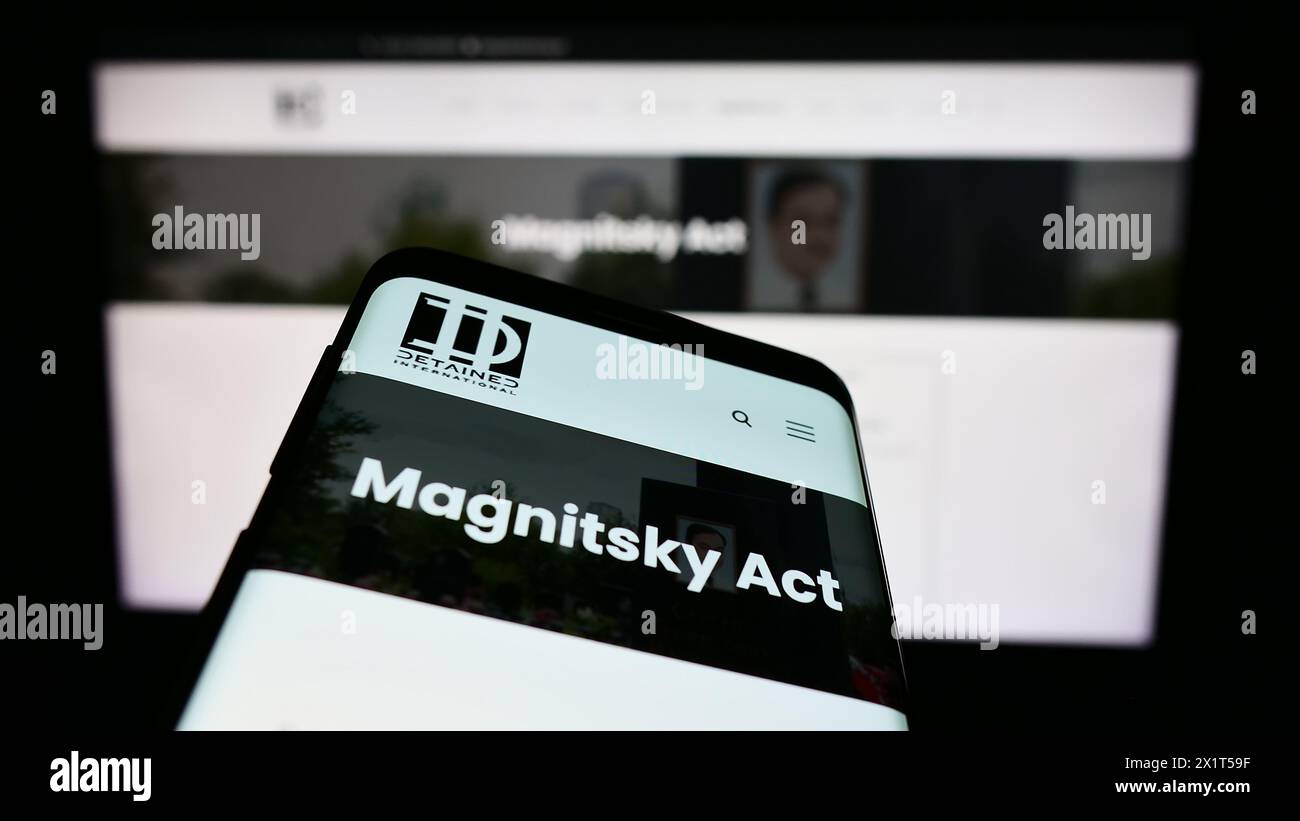 Smartphone mit Website und Logo der Rechtsanwaltskanzlei NGO inhaftiert International vor dem Monitor. Fokussieren Sie sich oben links auf der Telefonanzeige. Stockfoto