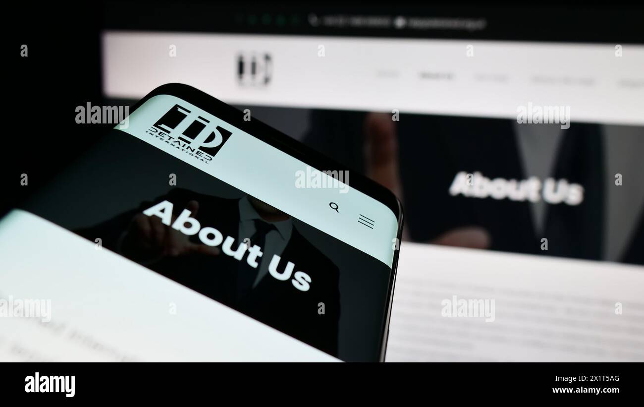 Handy mit Website und Logo der Rechtsanwaltschaft NGO inhaftiert International vor dem Monitor. Fokussieren Sie sich oben links auf der Telefonanzeige. Stockfoto