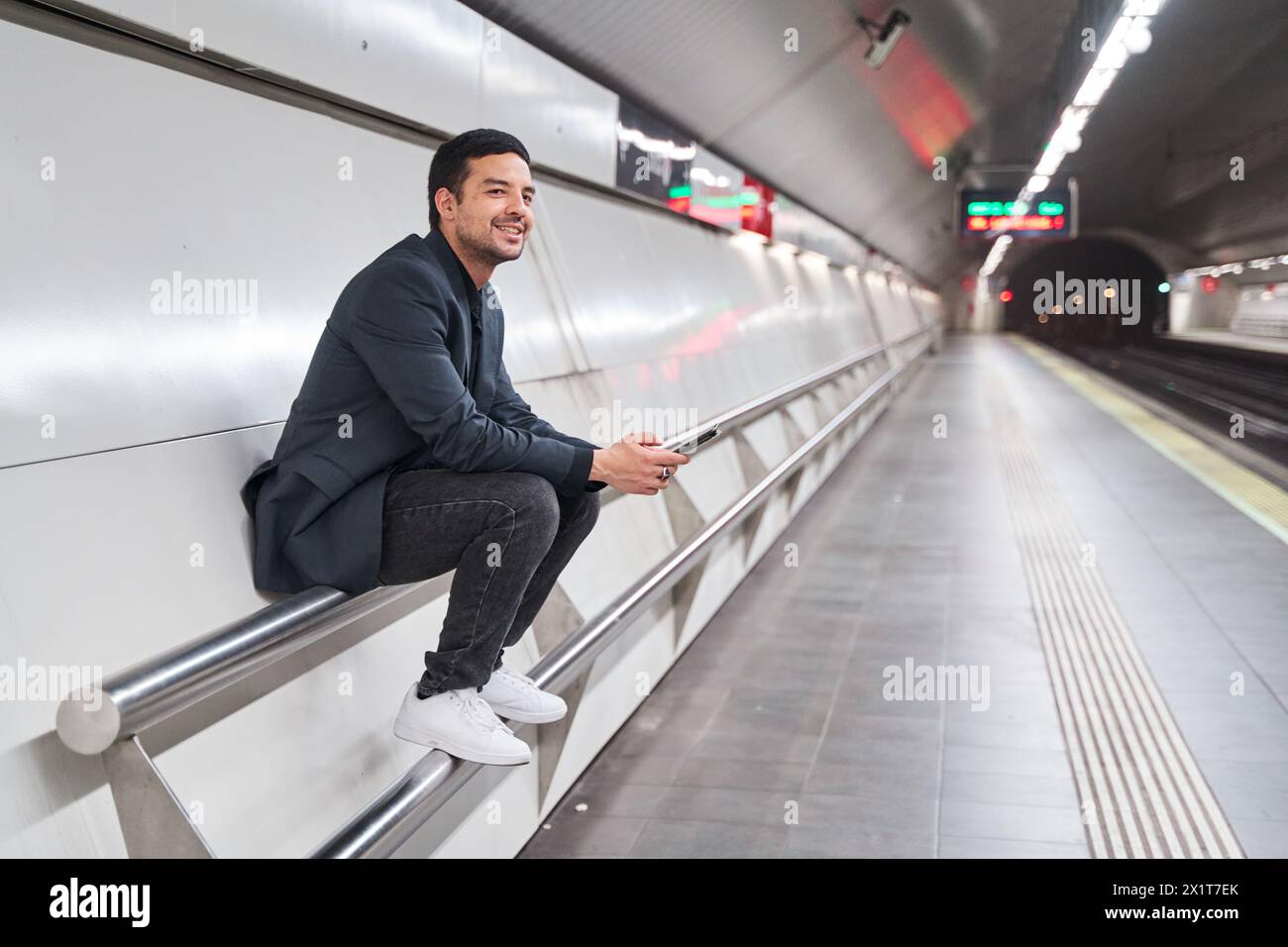 Mann, der auf der Station sitzt und auf die Metro wartet Stockfoto