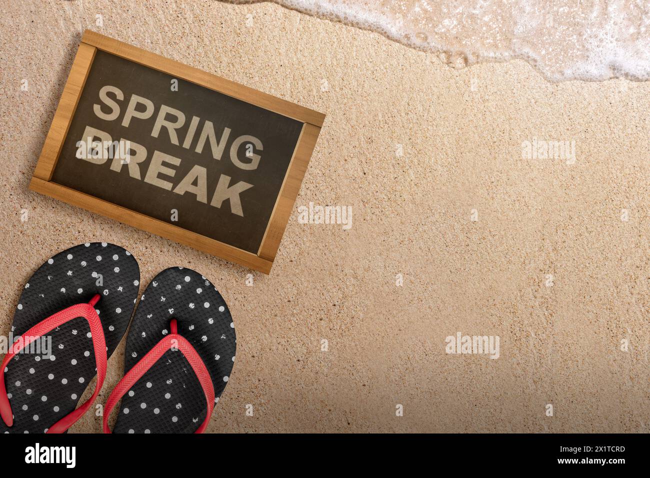 Slipper und kleine Tafel mit Frühlingsferien-Text am Sandstrand. Spring Break-Konzept Stockfoto