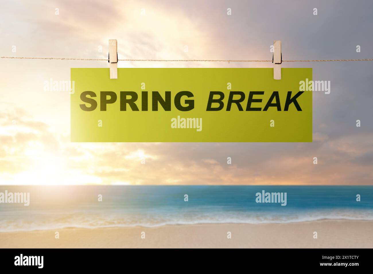 Papier hängt am Seil mit Frühlingsferien-Text am Strand. Spring Break-Konzept Stockfoto
