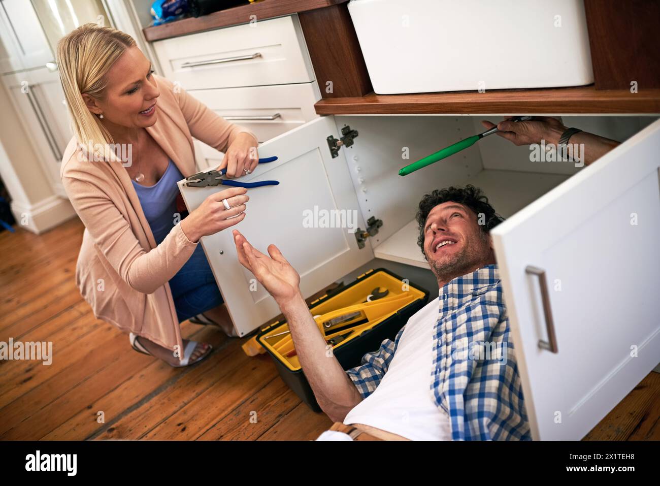 Dame, Helfer und Handwerker mit Werkzeugen zum Reparieren von Hausbecken, Abfluss oder kaputten Innenkanälen. Klempner, Arbeiter und Frau, die männliche Person repariert Stockfoto