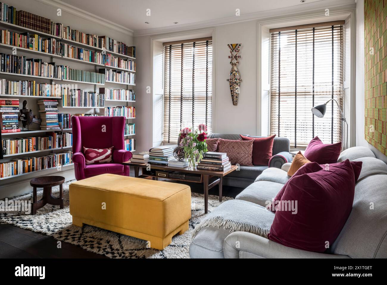 Kontrastierende Farben und Bücherregale mit der Privatsphäre venezianischer Jalousien in Chelsea Home, London, Großbritannien Stockfoto