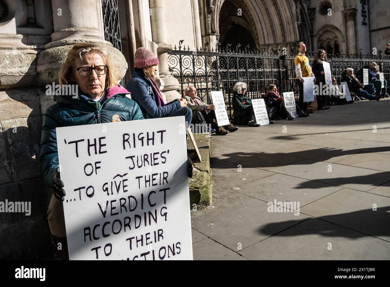 London, England, Großbritannien. April 2024. Königlicher Gerichtshof, London, Vereinigtes Königreich, 18. April 2024. Besorgte Bürger aus der Kampagne „Verteidigung unserer Geschworenen“ kommen am Londoner Royal Court of Justice zusammen und halten Plakate, die den Gesetzgebungskodex zitieren, der das Recht der Bürger auf ein Gericht durch eine Jury gleichrangiger Geschworener, „lebenswichtiger Schutz vor Machtmissbrauch seit der Magna Carta.“ Sie unterstützen Trudy Warner, 68, der erste Aktivist, der letztes Jahr ein solches Zeichen vor einem Gerichtshof in England hielt. Quelle: ZUMA Press, Inc./Alamy Live News Stockfoto