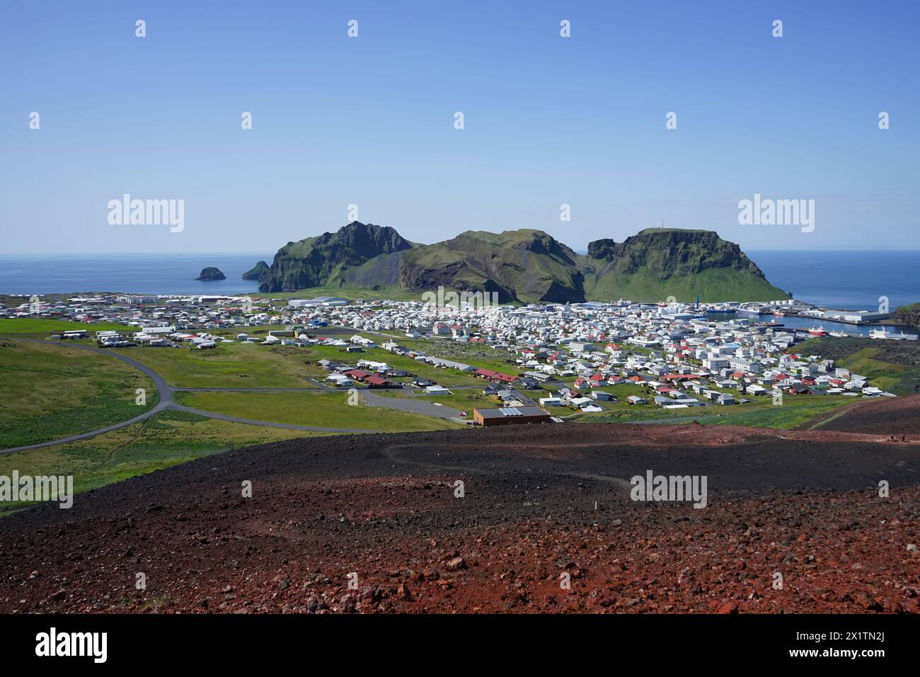 Blick auf Heimaey Stadt und Heimaklettur Berg von der Spitze des Eldfell Vulkankegels, Westman Inseln, Island Stockfoto
