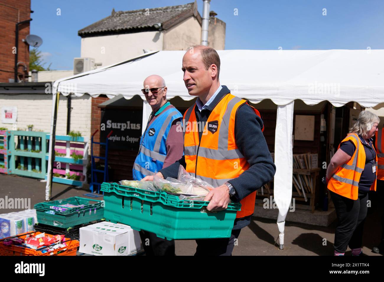 Britain's Prince William helps to loads trays of food into vans during a visit to Surplus to Supper, in Sunbury-on-Thames, Surrey, England, Thursday, April 18, 2024. The Prince visited Surplus to Supper, a surplus food redistribution charity, to learn about its work bridging the gap between food waste and food poverty across Surrey and West London. (AP Photo/Alastair Grant, pool) Stockfoto
