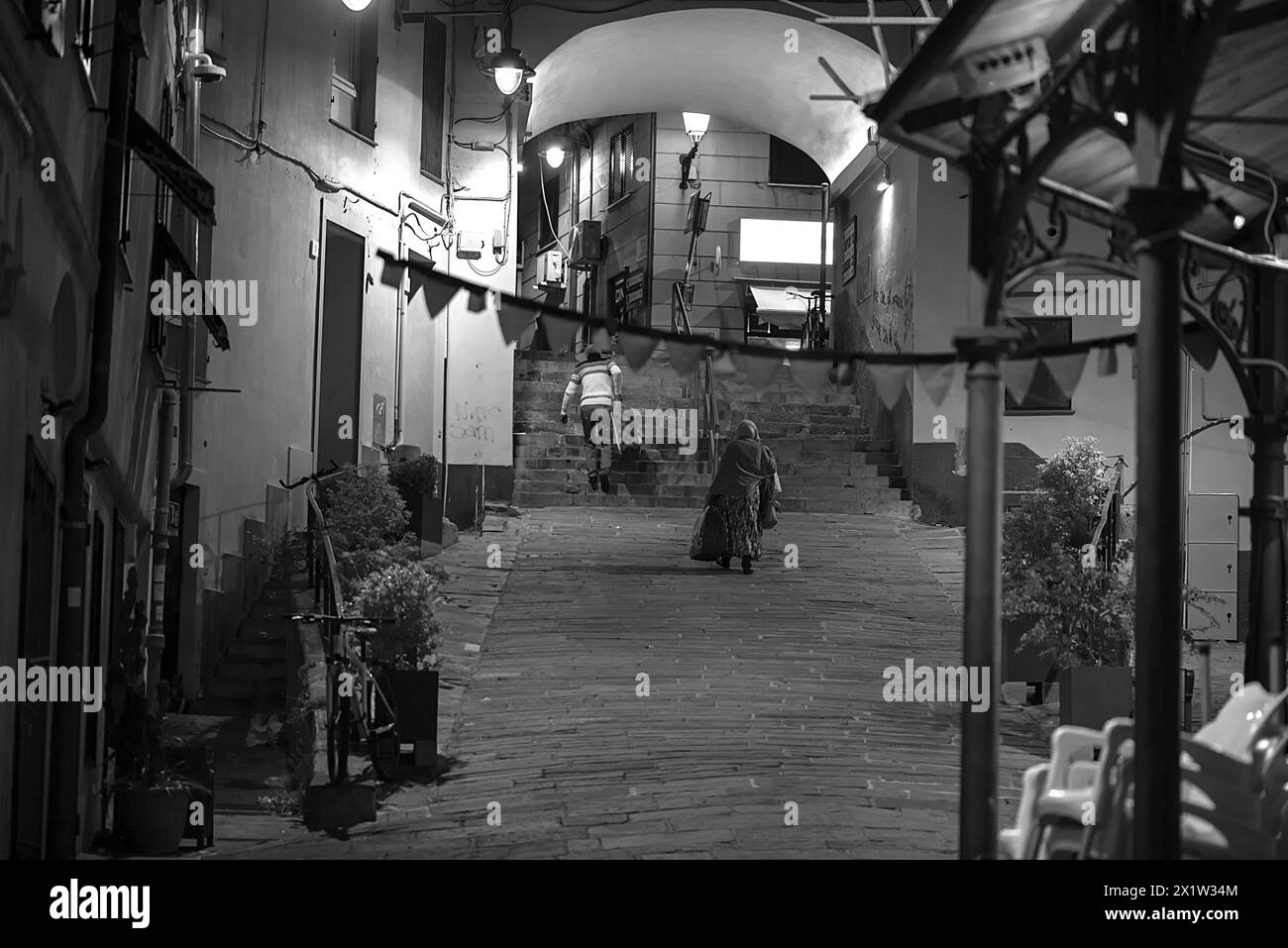 Zwei Bewohner mit Koffern, die abends von einer Reise nach Hause zurückkehren, Altstadt von Genua, Italien Stockfoto