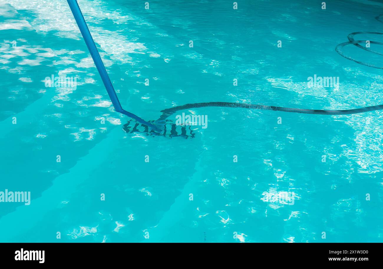 Poolpflege und -Reinigung mit Staubsaugerschlauch. Schwimmbad mit Saugschlauch reinigen Stockfoto