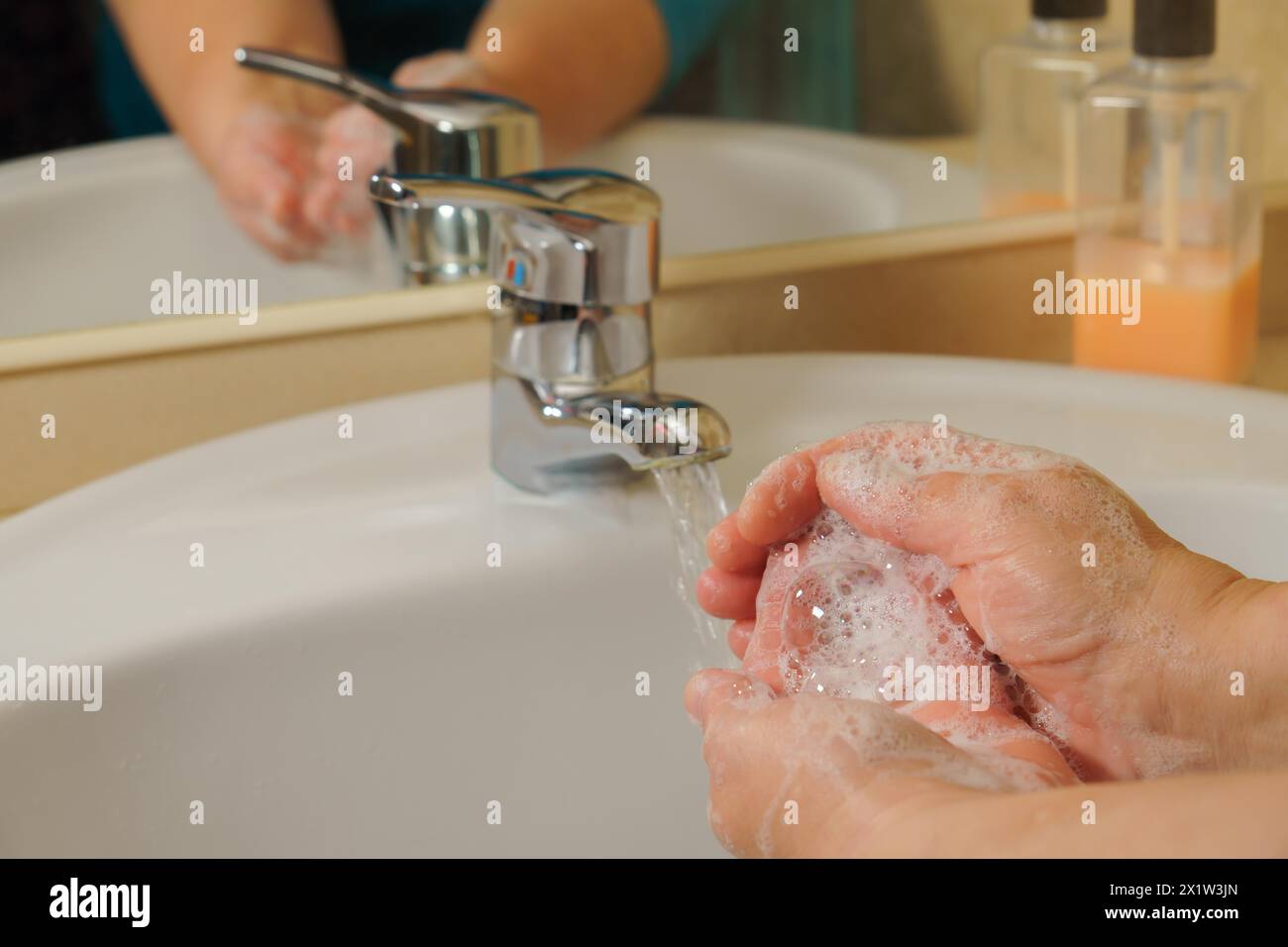 Nahaufnahme einer Frau, die ihre Hände mit Flüssigseife im Waschbecken wäscht. Handhygiene durch Bakterien. Schaumstoffe in Frauenhänden Stockfoto