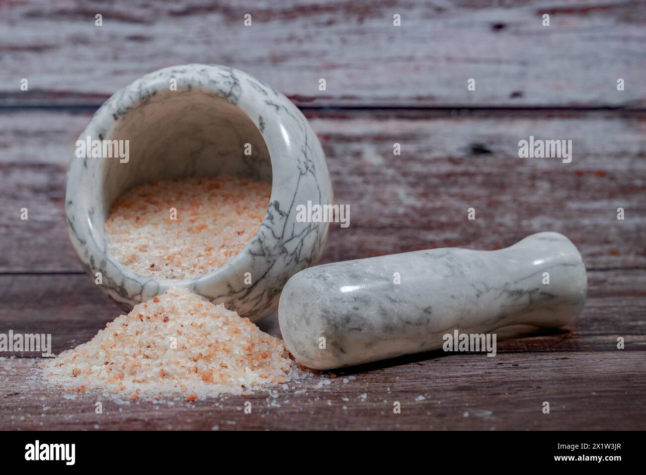 Rosa Himalaya-Salz in einem Keramikmörtel auf einem Holztisch mit Kopierraum Stockfoto