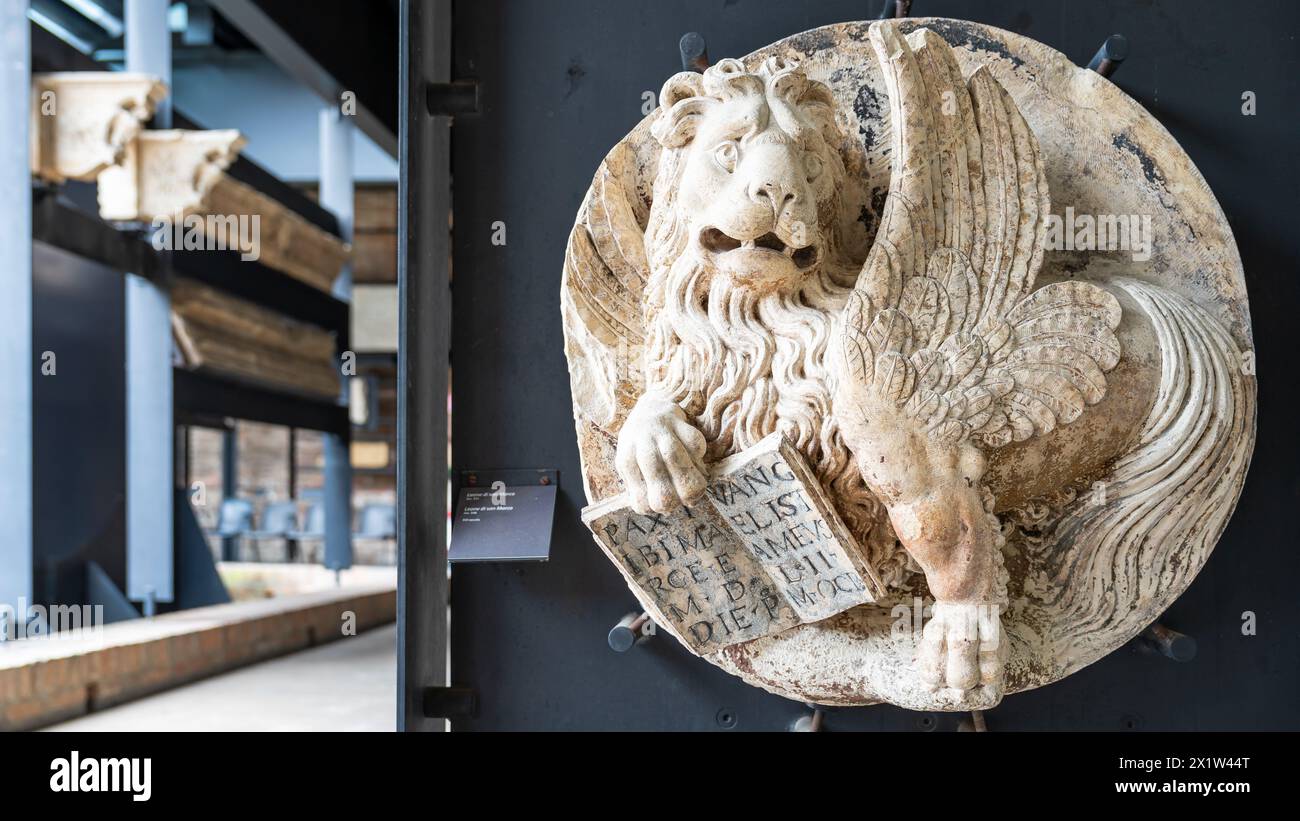 Nahaufnahme der antiken Skulptur eines geflügelten Löwen, der in ein rundes Marmorstück geschnitzt wurde Stockfoto