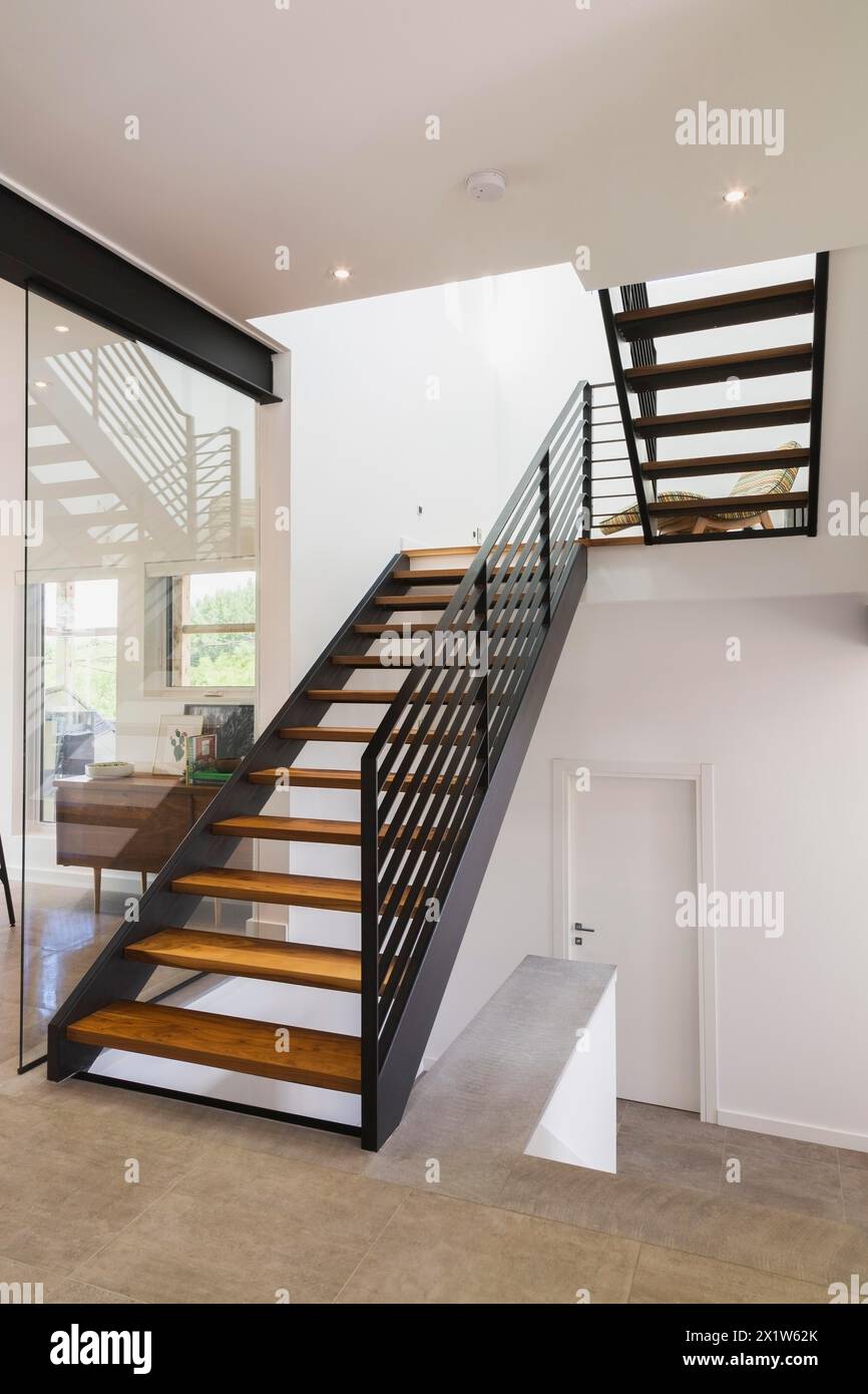 Amerikanisches Walnussholz und schwarz pulverbeschichtete kaltgewalzte Stahltreppen in einem modernen Haus im Würfelstil, Quebec, Kanada Stockfoto