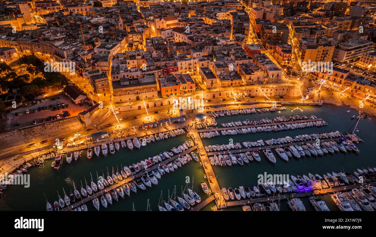 Blick aus der Vogelperspektive auf das Meer und die Altstadt von Bisceglie in Apulien mit Drohne bei Nacht. Stockfoto