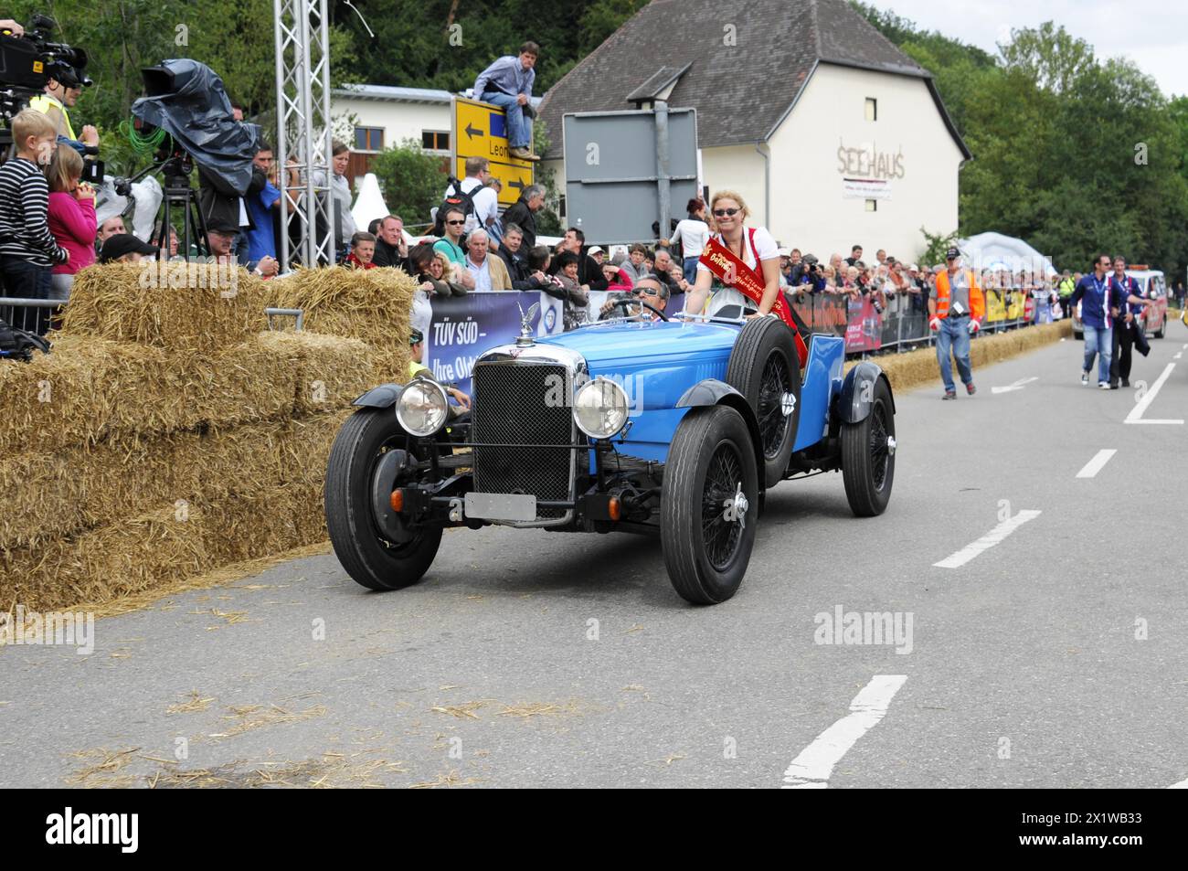 Ein alter Rennwagen wird von einer Person mit einer Flagge begleitet, Zuschauer beobachten die Veranstaltung, SOLITUDE REVIVAL 2011, Stuttgart, Baden-Württemberg, Deutschland Stockfoto