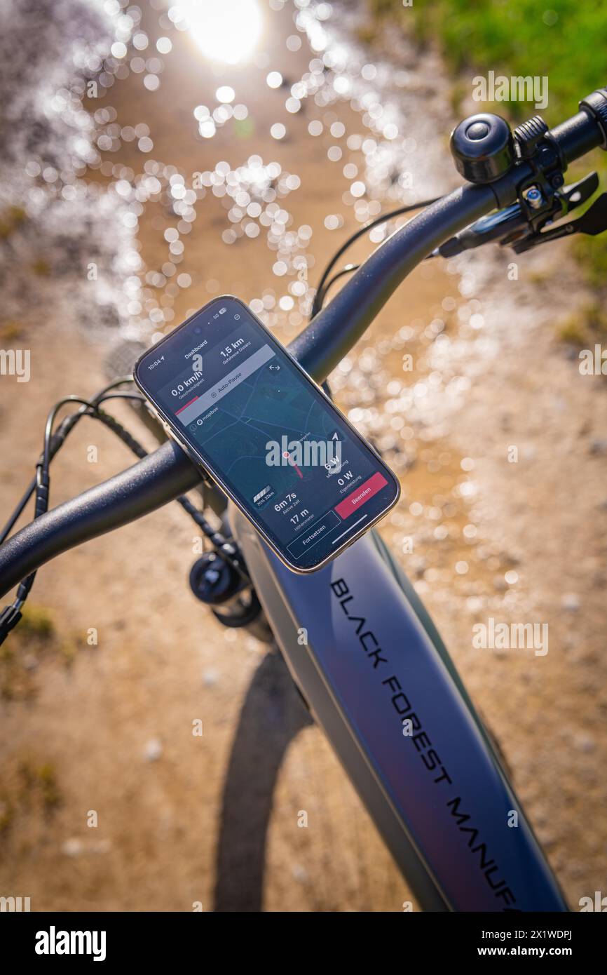 Blick über den Lenker eines E-Bikes mit Display und Smartphone im Sonnenlicht, Frühling, E-Bike Waldbike, Gechingen, Schwarzwald, Deutschland Stockfoto