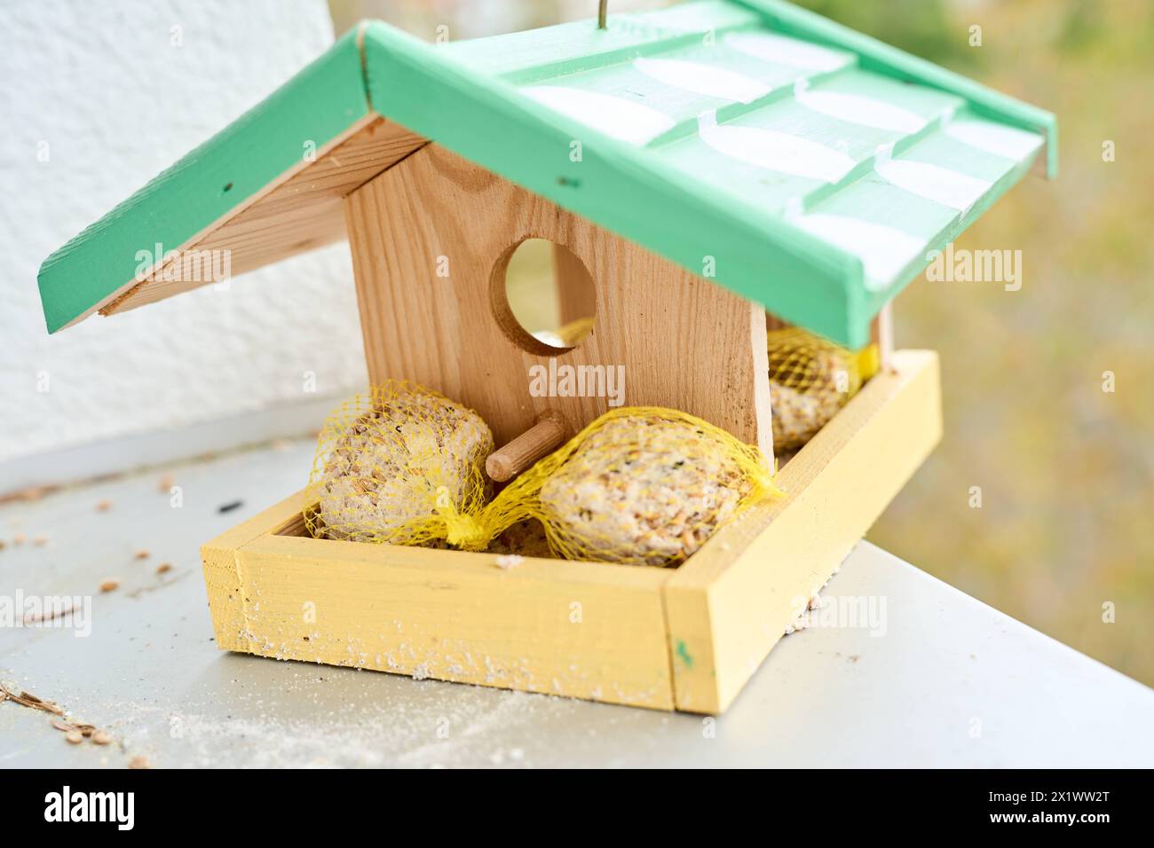 Augsburg, Bayern, Deutschland - 17. April 2024: Ein Vogelhaus aus Holz mit Vogelfutter *** ein Vogelhaus aus Holz mit Vogelfutter Stockfoto