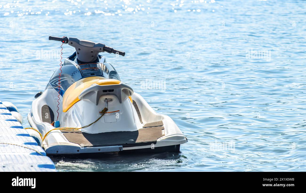 Jet-Ski mit einem Seil an einem modularen schwimmenden Kunststoff-Ponton-Anlegeplatz am Meer gebunden Stockfoto