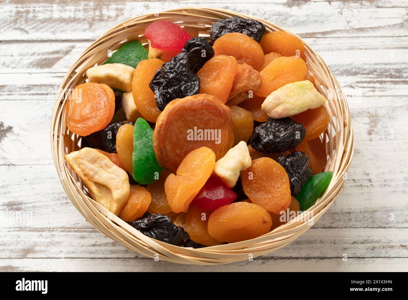 Korb mit getrockneten Früchten, Tutti Frutti, auf hölzernem Hintergrund Stockfoto