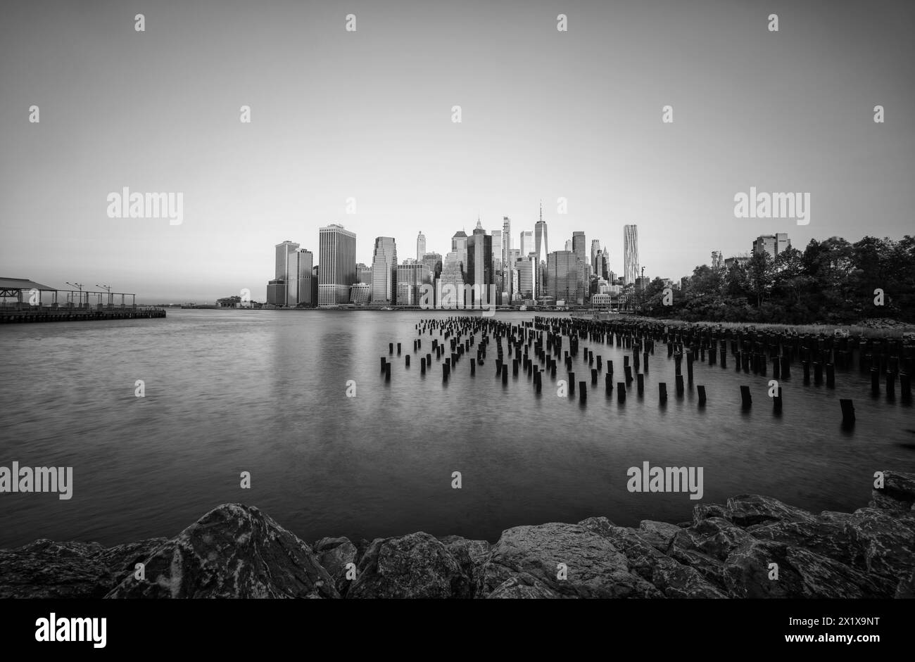 Wolkenkratzer im Finanzviertel Lower Manhattan, die am frühen Morgen New York über den East River vom Old Pier 1 im Brooklyn Bridge Park Greenway aus gesehen werden Stockfoto