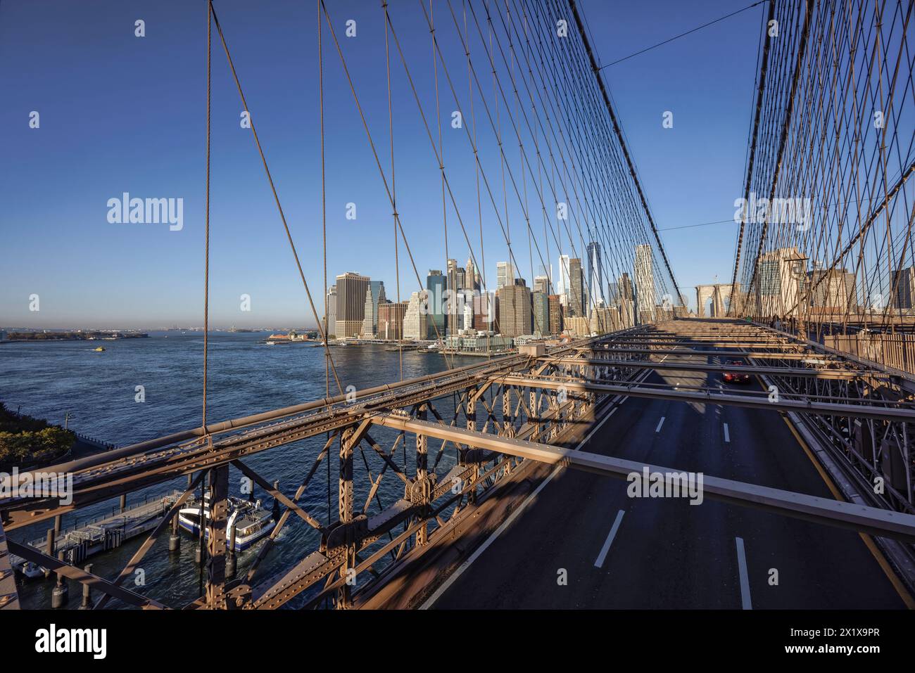 Struktur der Brooklyn Bridge und der Straßenweg über den East River, der Brooklyn und Lower Manhattan verbindet, mit Wolkenkratzern von Lower Manhattan dahinter, New York Stockfoto