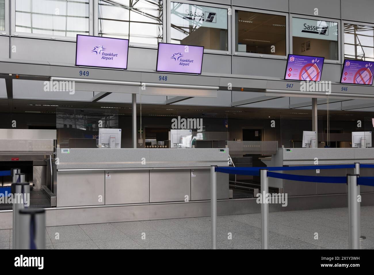 Frankfurt International Airport, Deutschland - 19. Februar 2024: Displays mit Werbung für den Frankfurter Flughafen hängen über der leeren Anzahl der Check-in Stockfoto