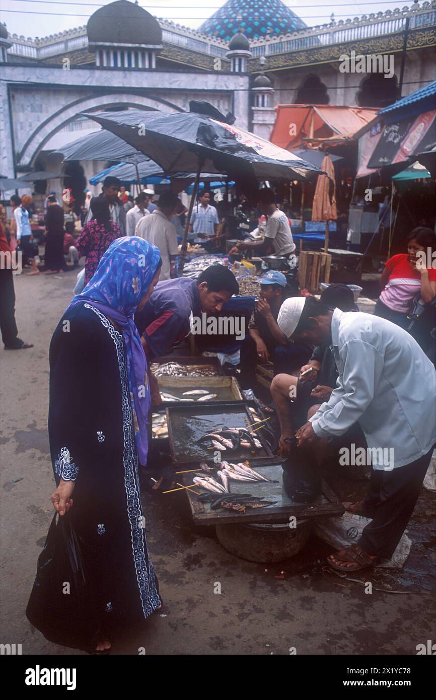 Frau in islamischer Kleidung mit Fischverkäufern, Martapura Markt, Martapura Fluss, genommen 2003, Banjarmasin, Kalimantan, Indonesien Stockfoto