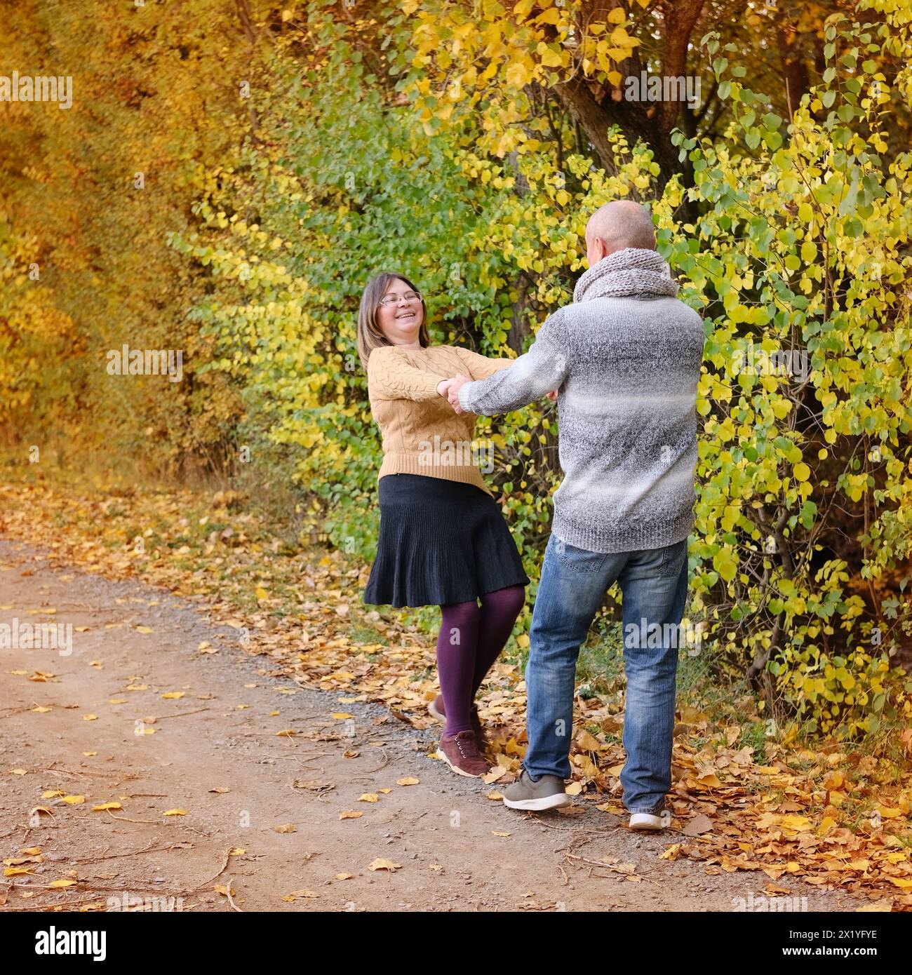 Alter Mann und Frau haben Spaß beim Tanzen im Herbstpark vor dem Hintergrund von Bäumen, das Konzept eines gesunden Lebensstils, gute Laune, Glück bei einem Stockfoto