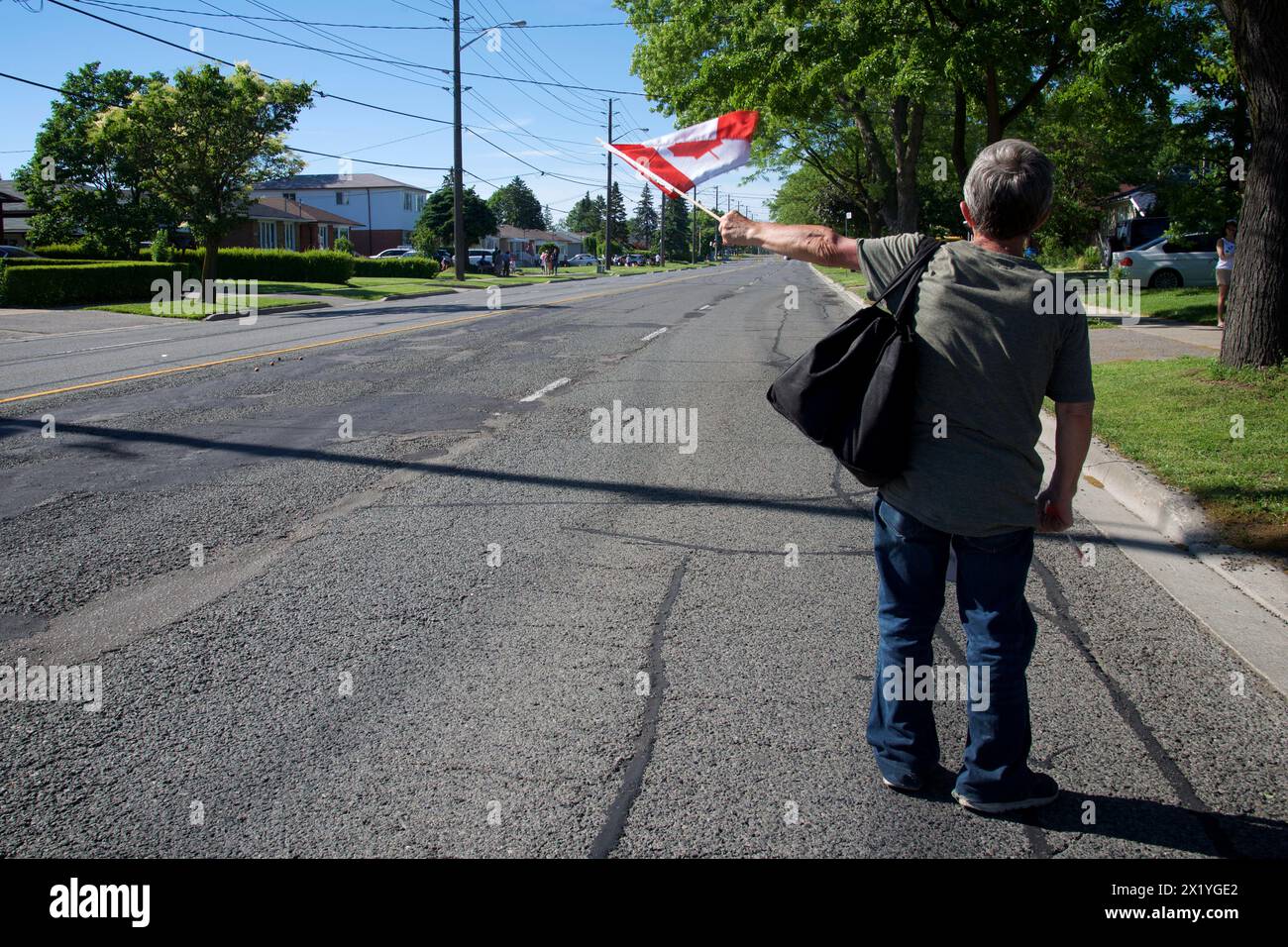 Mann, der kanadische Flaggen schwenkt bei der Canada Day Parade Stockfoto