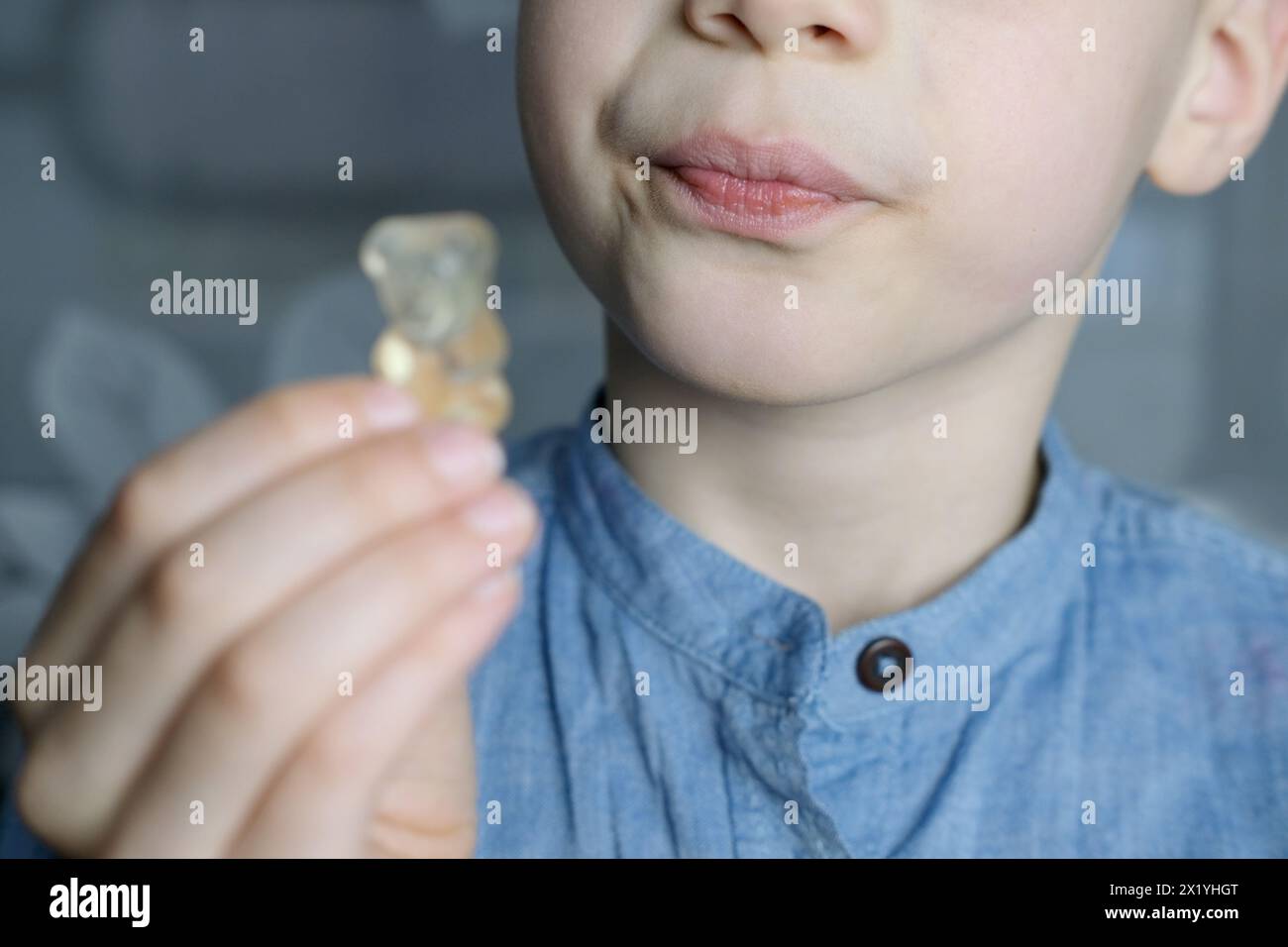 Junge, Kind hält in der Hand, will gallertartige Süßigkeiten essen, Gummibär, Konzept der Kinderdelikatesse, gesunde und ungesunde Nahrung, Halal-Nahrung Stockfoto