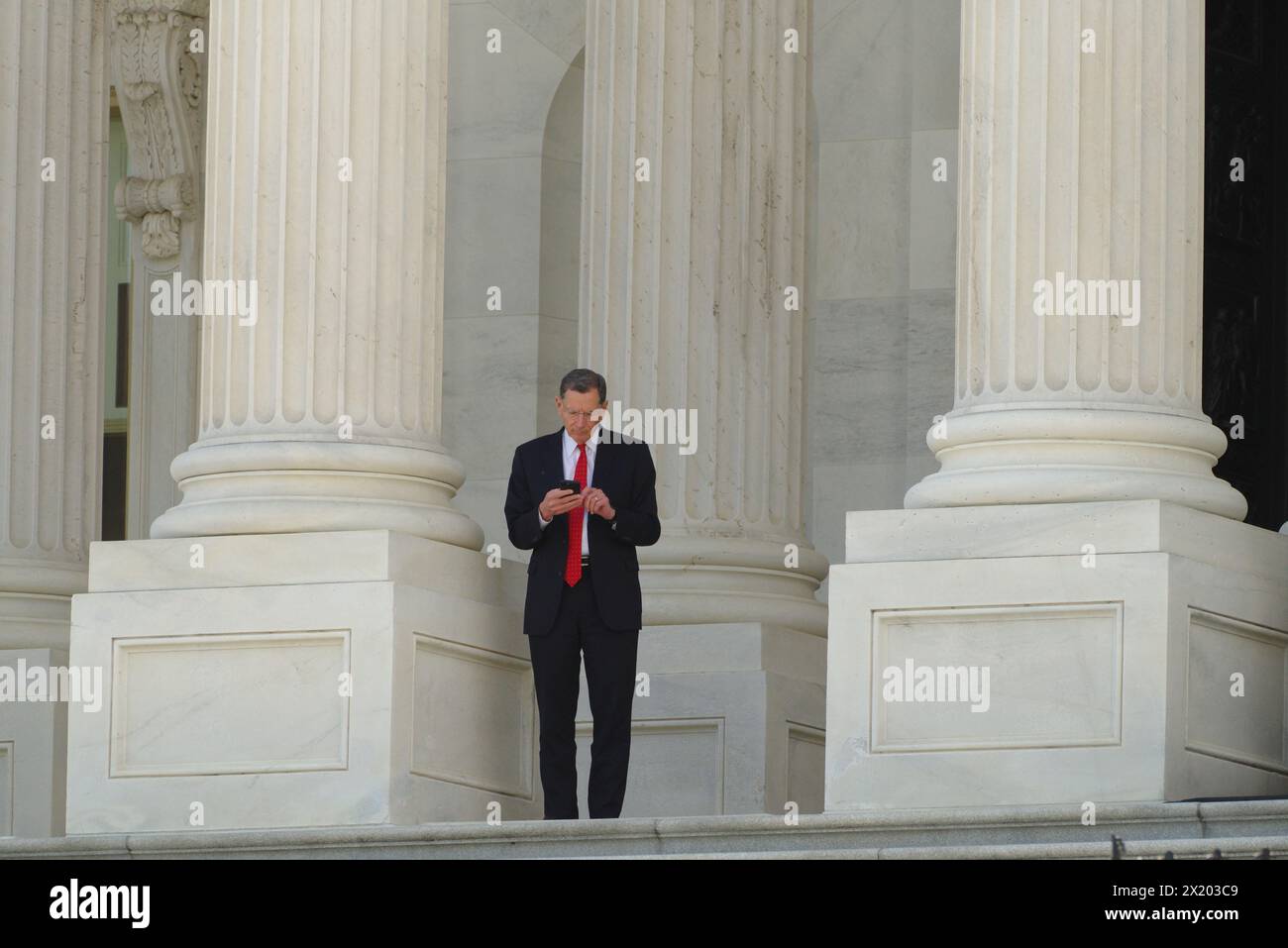 Washington, DC, USA. April 2024. US-Senator John Barrasso (R-Wyo) Überprüft sein Handy auf der Senatstreppe des Kapitols. Stockfoto