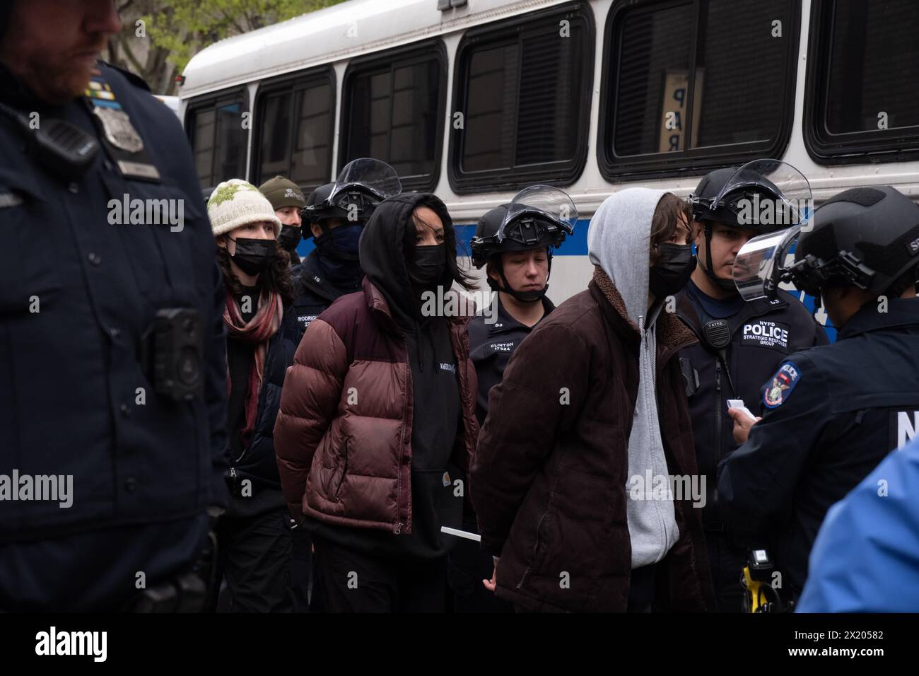 New York, Usa. April 2024. Studenten, geführt von NYPD SRG-Offizieren, warten auf den NYPD-Bus in der 114. Straße. Pro-palästinensische Studenten an der Columbia University, die am Tag zuvor ein „Gaza Solidarity Encamp“ auf dem Campus eingerichtet hatten, werden verhaftet, nachdem Columbia das NYPD angewiesen hatte, sie zu räumen. Quelle: SOPA Images Limited/Alamy Live News Stockfoto