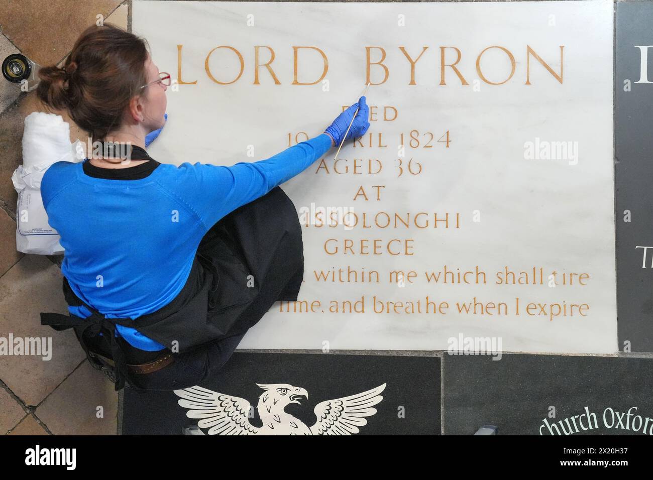 Konservatorin Lucy Ackland reinigt Lord Byrons Gedenkstein in der Poets' Corner in der Westminster Abbey in London, vor einer Kranzniederlegung am Freitag zum 200. Jahrestag seines Todes. Bilddatum: Donnerstag, 18. April 2024. Stockfoto