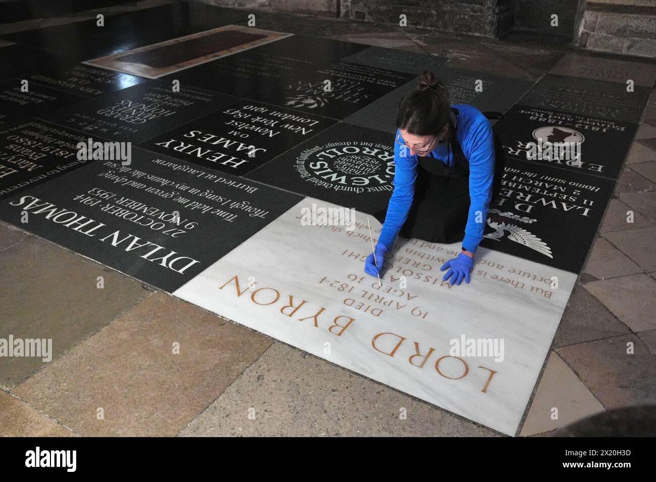 Konservatorin Lucy Ackland reinigt Lord Byrons Gedenkstein in der Poets' Corner in der Westminster Abbey in London, vor einer Kranzniederlegung am Freitag zum 200. Jahrestag seines Todes. Bilddatum: Donnerstag, 18. April 2024. Stockfoto
