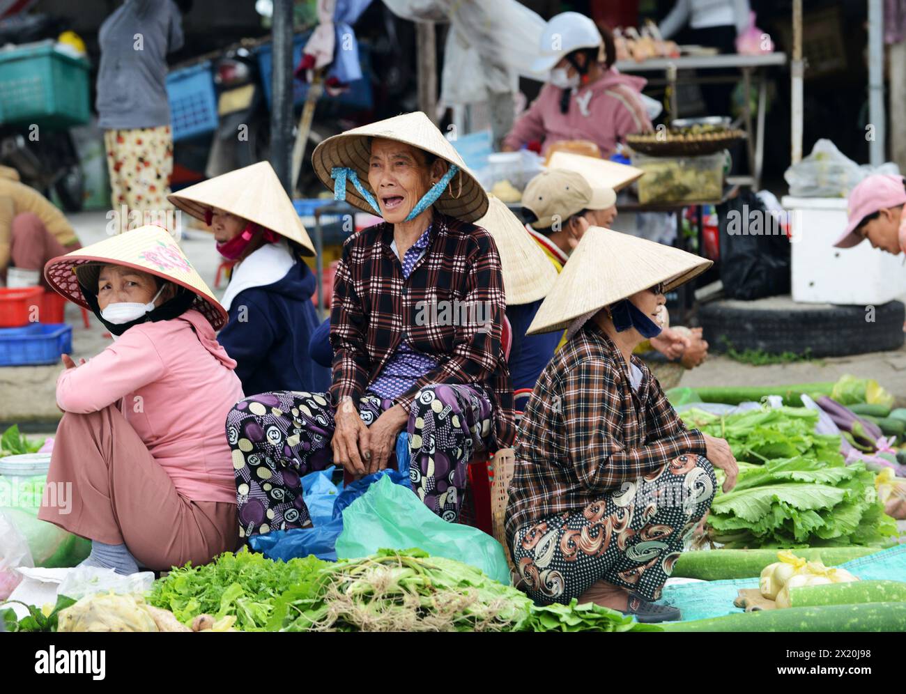 Vietnamesische Frauen verkaufen Gemüse und grüne Kräuter auf einem kleinen ländlichen Markt in der Provinz Quảng Nam, Vietnam. Stockfoto