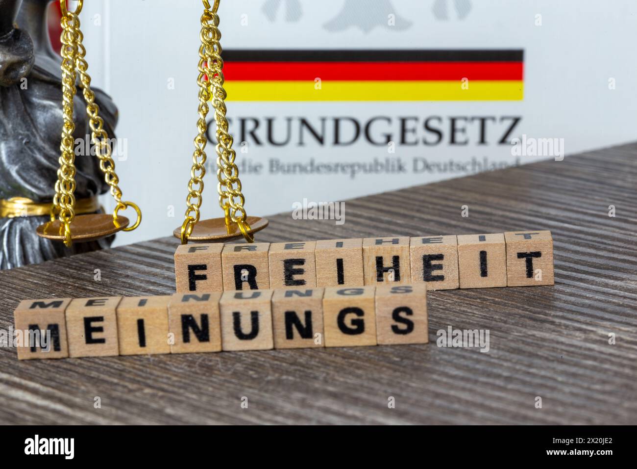 Symbolbild der Meinungsfreiheit in Deutschland: Das Wort MEINUNGSFREIHEIT in Buchstabenwürfeln neben den Maßstäben der Gerechtigkeit und des Grundgesetzes Stockfoto