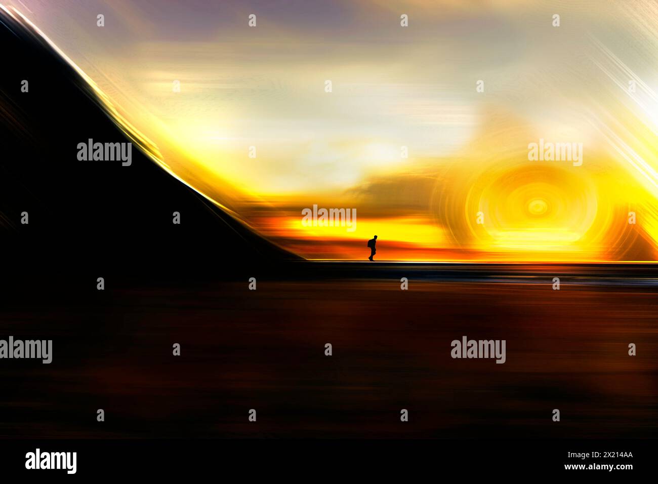 Eine Silhouette einer Person, die bei Sonnenuntergang am Strand steht. Der Himmel ist orange und die Sonne untergeht. Stockfoto