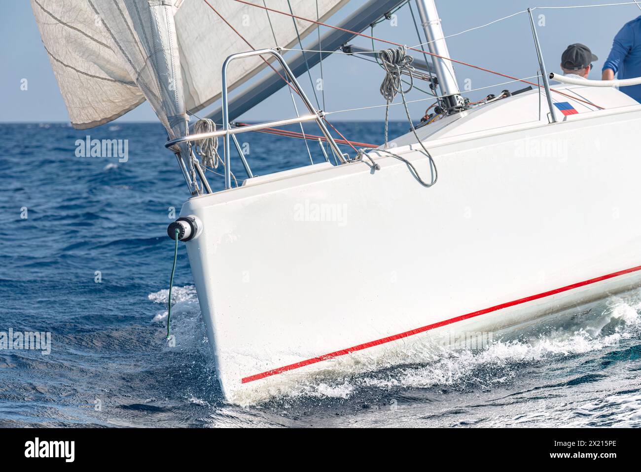 Nahaufnahme eines Segelbootes mit Segeln, das durch das blaue Meer navigiert Stockfoto