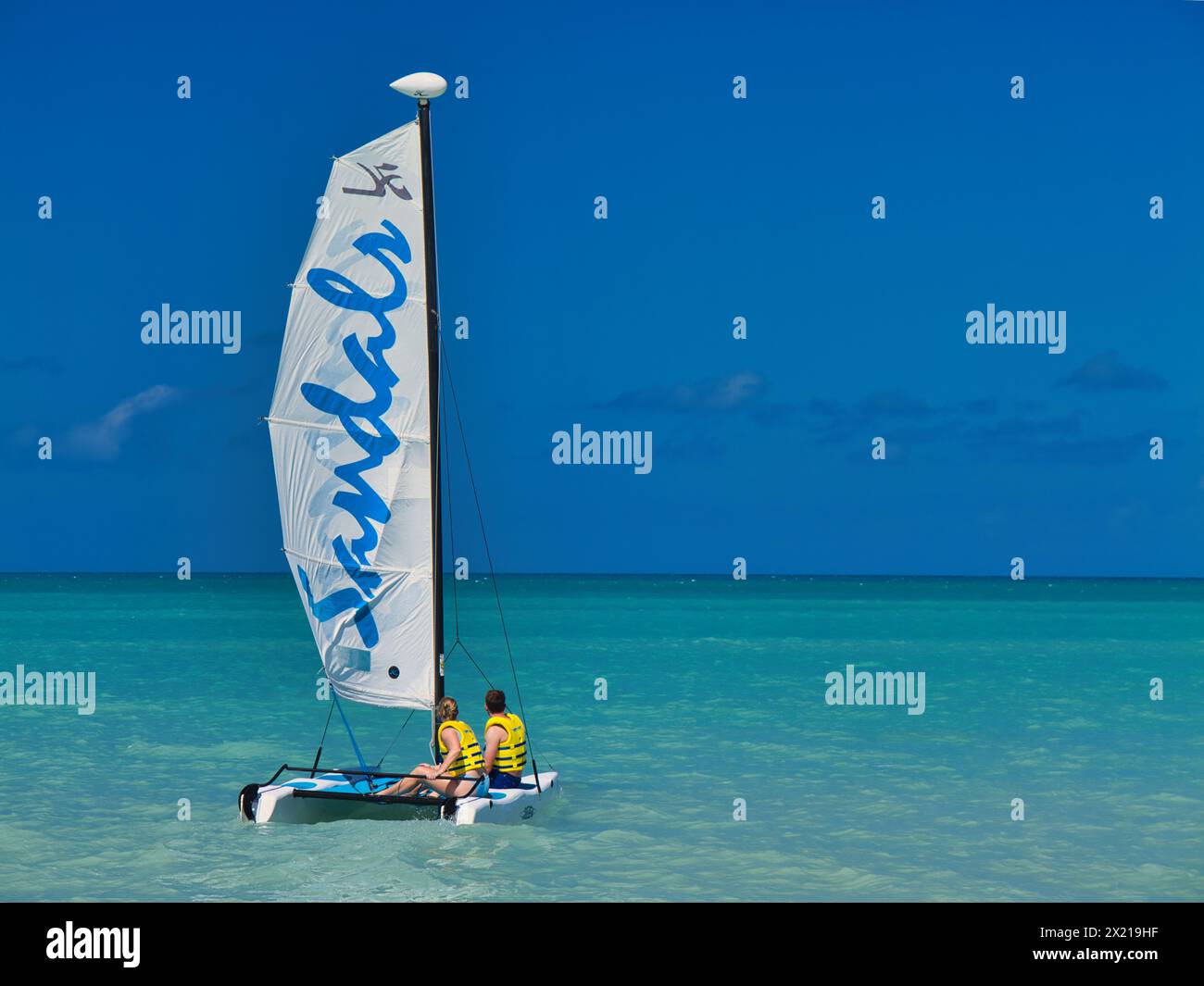 Antigua - 26. Januar 2024: Zwei Personen an Bord eines Freizeitbootes der Marke Sandals auf türkisfarbenem Wasser in der Dickenson Bay auf der Karibikinsel Antigua. Stockfoto