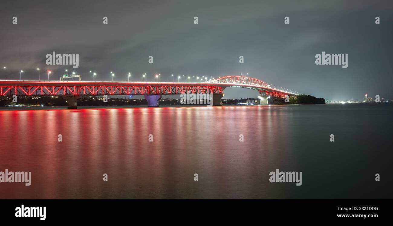 Rote Lichter leuchten auf der Auckland Harbour Bridge zur Unterstützung des jährlichen Poppy Day. Stockfoto