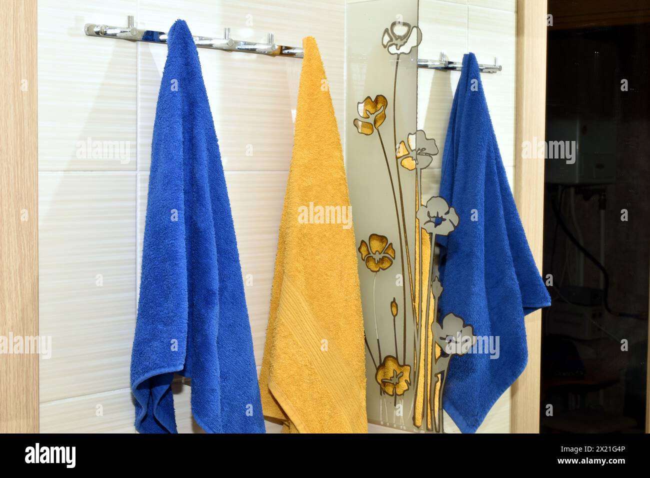 Kleiderbügel im Bad hängen an Handtüchern, die sich im Spiegel spiegeln. Stockfoto