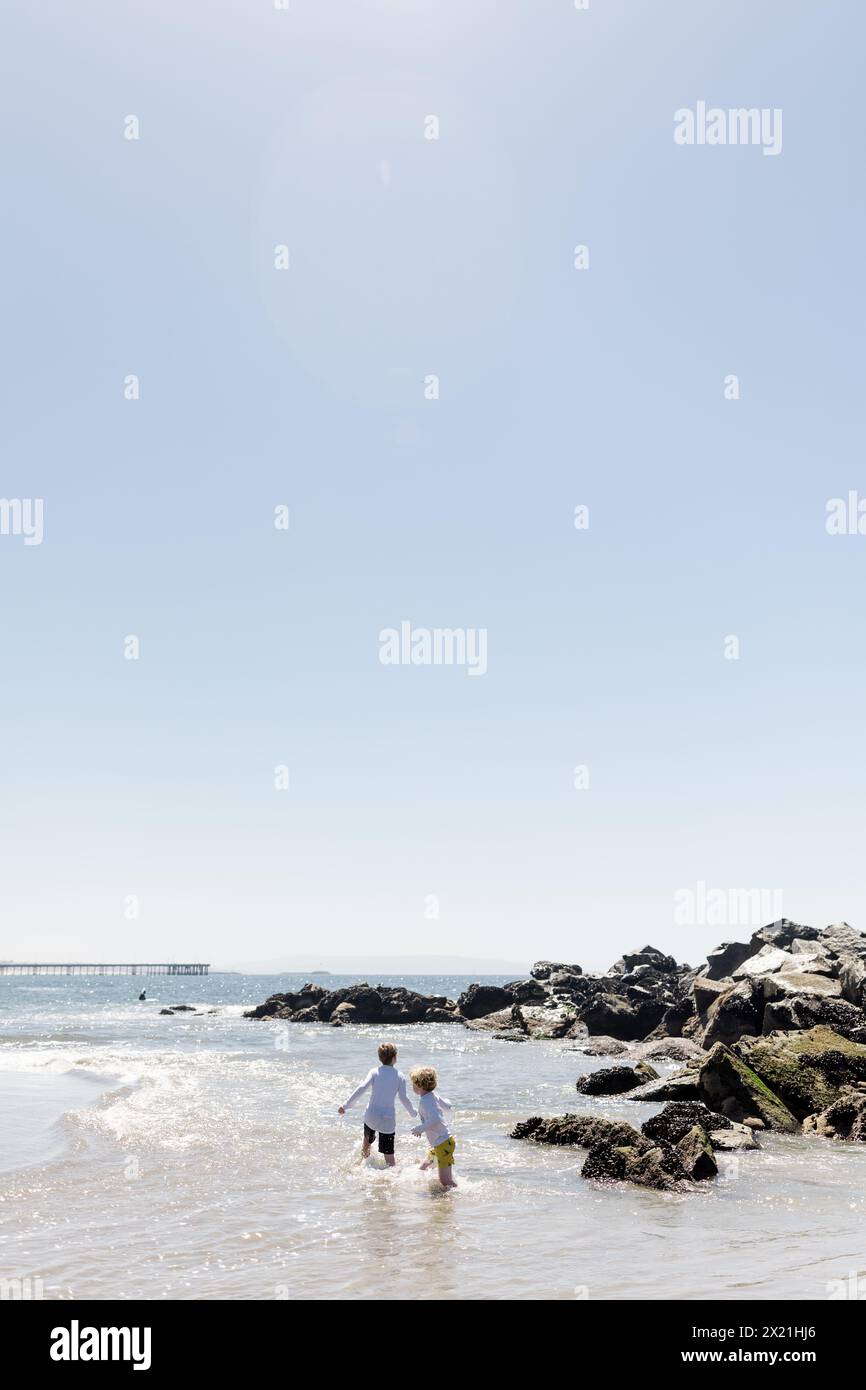 Brüder spielen am sonnigen Tag im Ozean in Venice Beach, CA Stockfoto