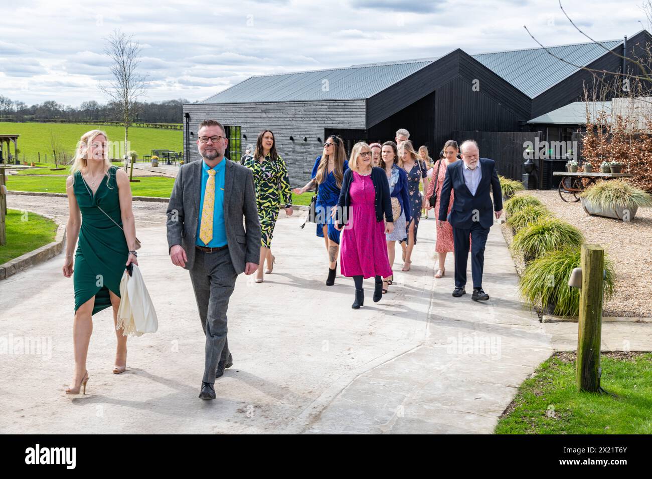 Hochzeitsgäste Freunde und Familie gehen zu einer Hochzeitszeremonie auf der Botley Hill Farm in Surrey, Großbritannien Stockfoto