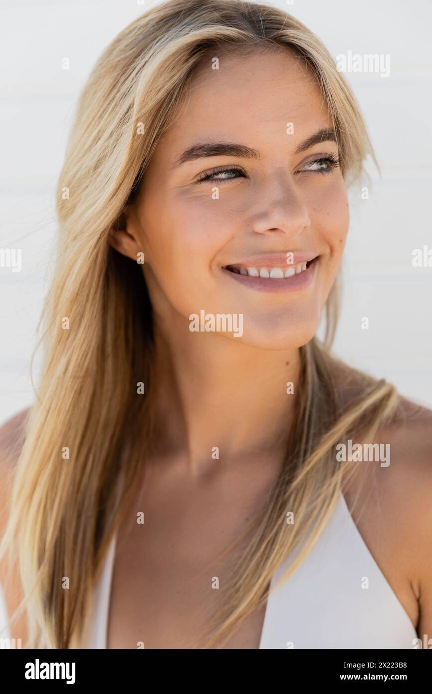 Eine junge blonde Frau mit langen Haaren lächelt an einem sonnigen Tag in Miami Beach warm in die Kamera. Stockfoto