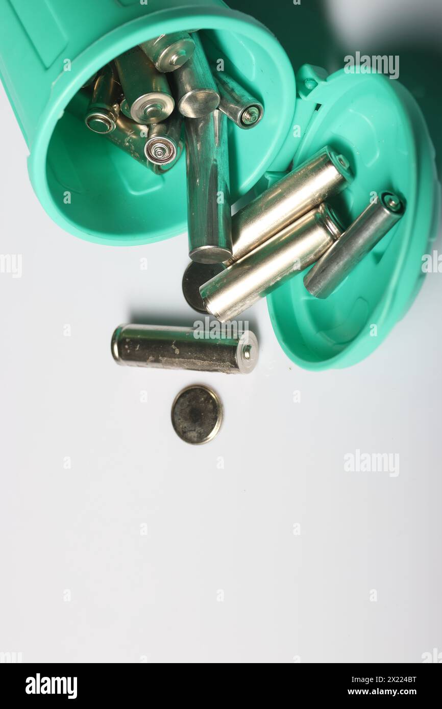 Miniaturszene mit einer starken Botschaft: Alte Fingerbatterien in einem winzigen Abfalleimer, die sich für Recycling und Umweltbewusstsein einsetzen Stockfoto