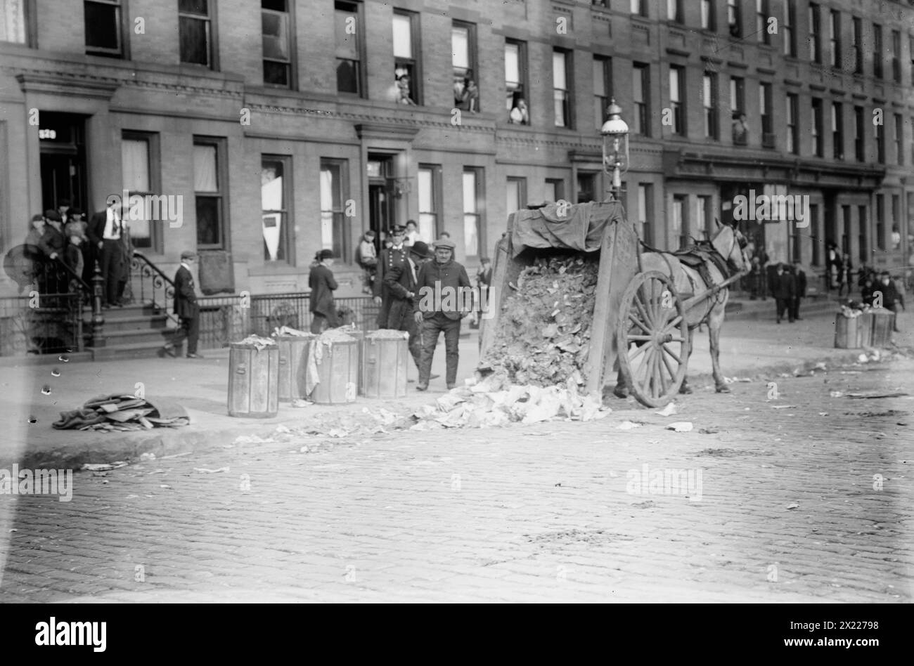 New Yorks Straßen, 1911. Zeigt einen von Pferden gezogenen Müllwagen, dessen Ladung während eines Müllstreiks in New York City vom 8. Bis 11. November 1911 auf die Straße geworfen wurde. Stockfoto