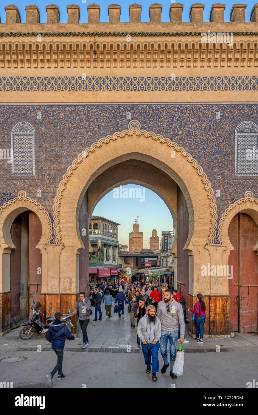 Eine Gruppe von Menschen, die vor dem historischen Bab Boujloud, auch bekannt als das Blaue Tor, in der Medina von Fès, Marokko, spazieren gehen. Stockfoto