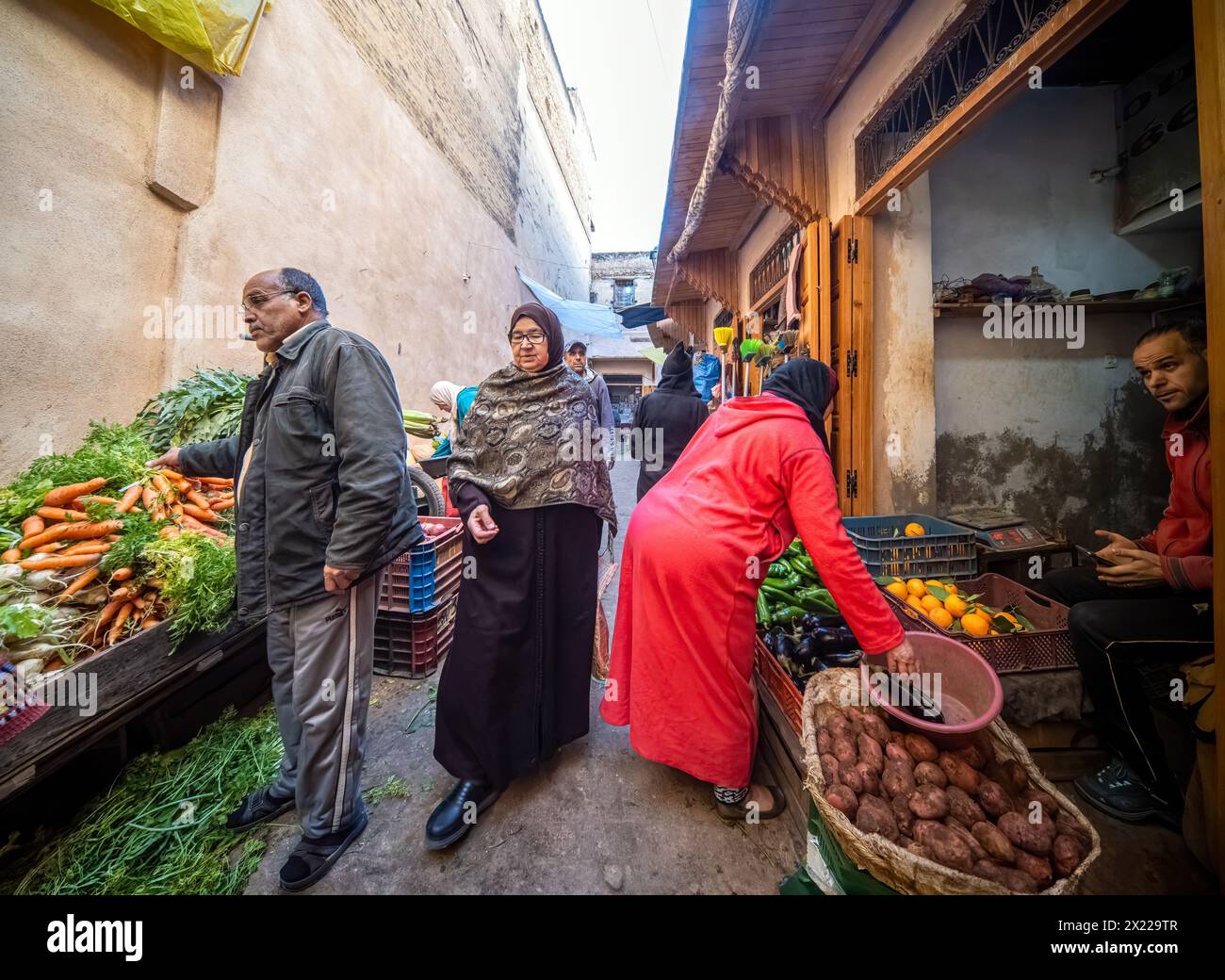 Einheimische kaufen frische Produkte an einem lebhaften Marktstand in Fès. Stockfoto