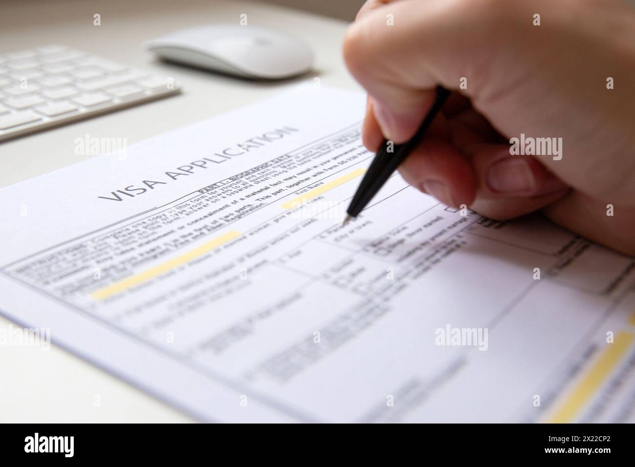 Nahaufnahme einer weiblichen Hand, die ein Visumantragsdokument ausfüllt Stockfoto