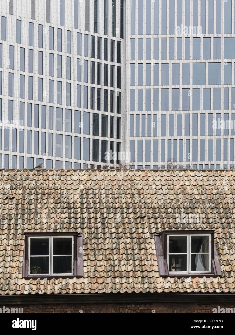 Die kontrastierenden architektonischen Stile in Malmö, Schweden, werden hier festgehalten und zeigen die altmodische Dachkachel eines historischen Gebäudes im f Stockfoto